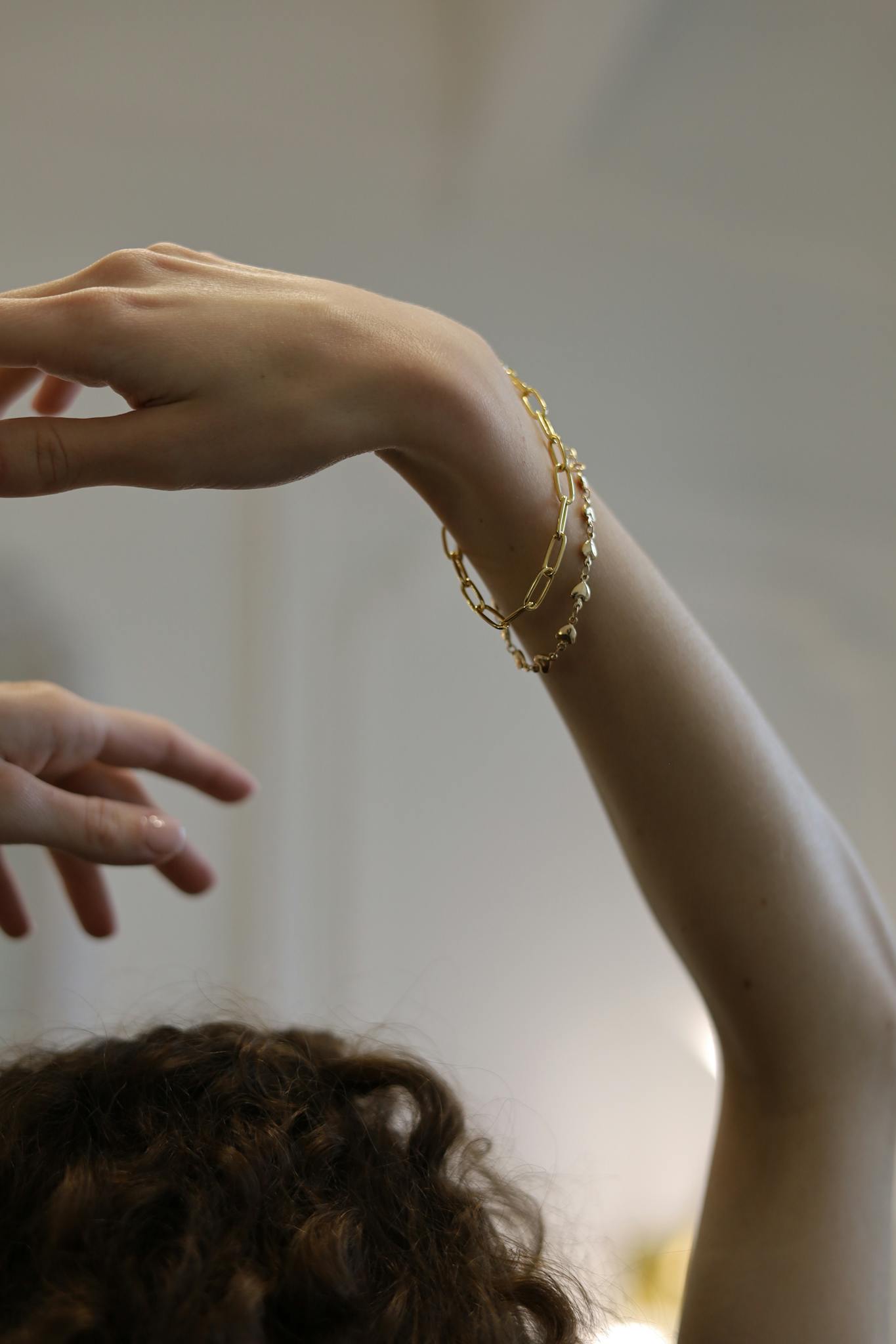 Close-up of elegant gold bracelets adorning an arms in an artistic pose.